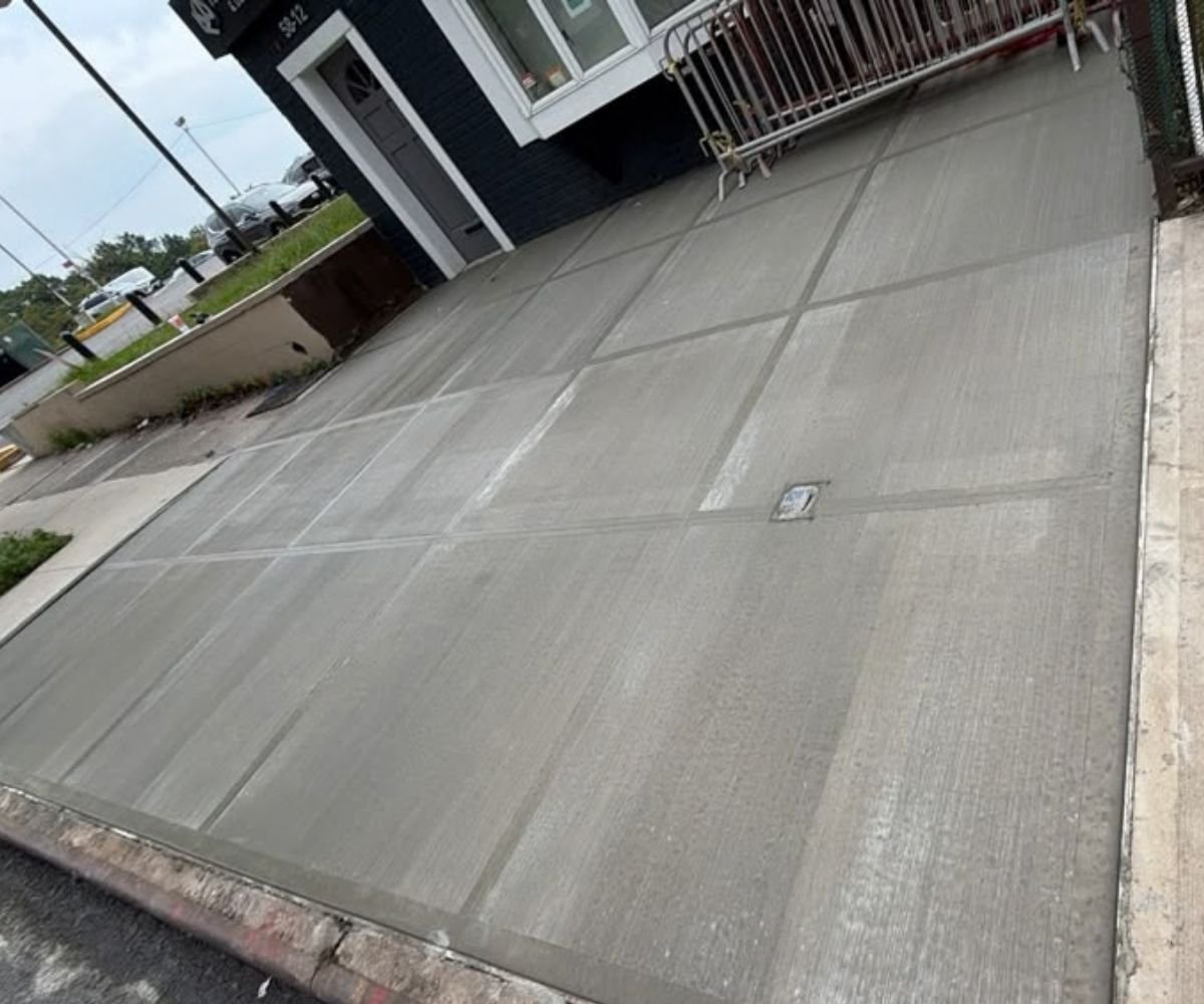 Newly replaced concrete sidewalk along the commercial property frontage on Francis Lewis Boulevard in Oakland Gardens, Queens.