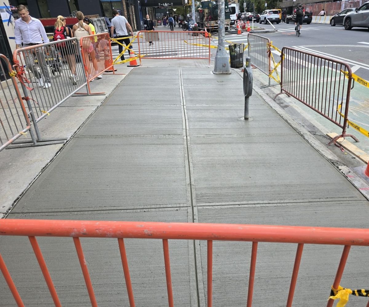 Newly installed concrete sidewalk at 1700 2nd Ave in Yorkville, Manhattan, showing smooth, level slabs with safety barricades following sidewalk replacement by FY Sidewalk.
