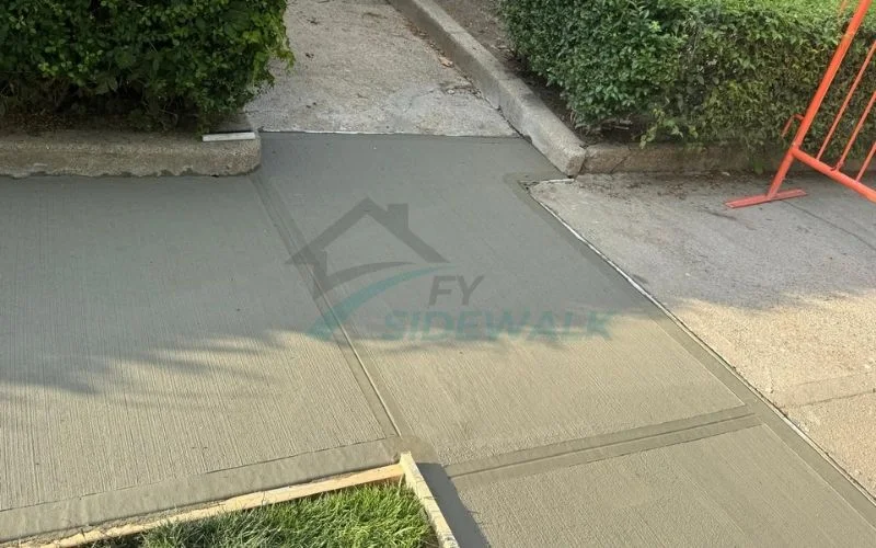 repaired concrete sidewalk section outside a queens home with clean finishing