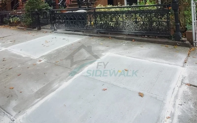 repaired concrete sidewalk outside a residential property in the bronx