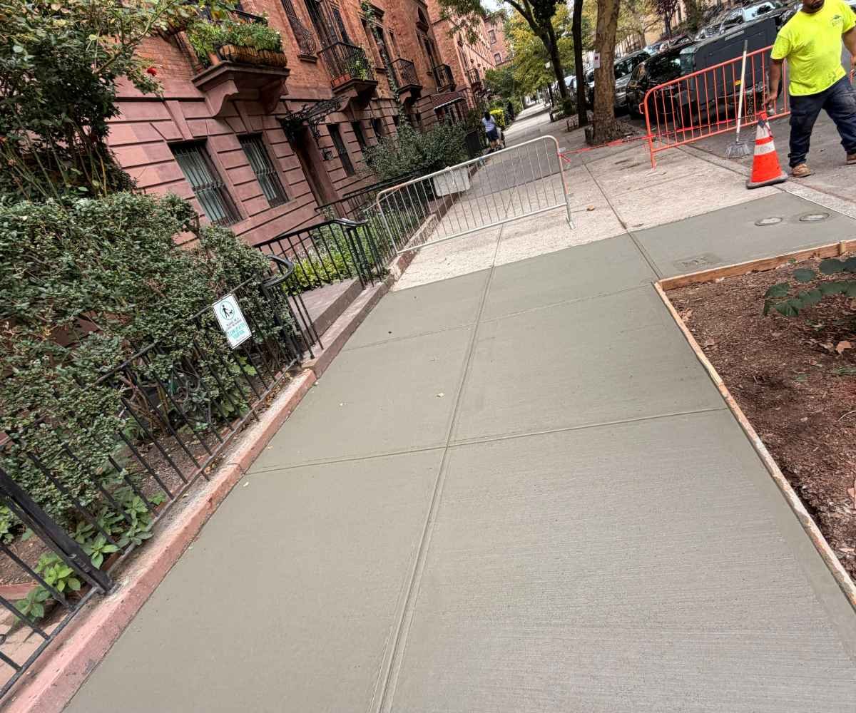 Completed concrete sidewalk replacement at 227 W 139th St in Harlem after tree-root damage and DOT violation repairs.